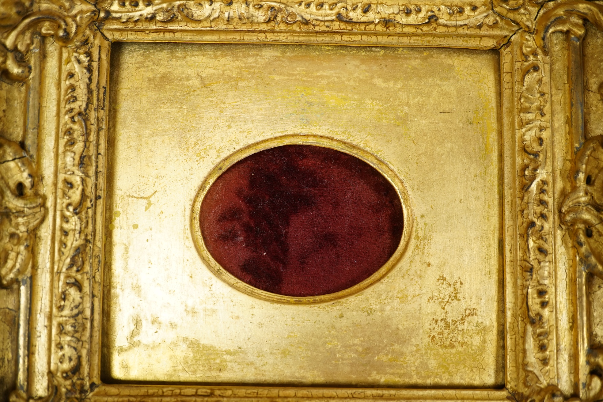 A gilt decorated sun burst clock frame, 63cm wide and a mid 19th century ornate gilt miniature frame
